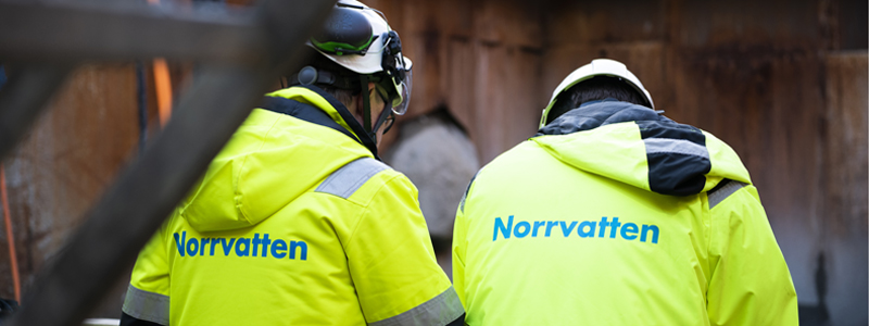 Två av Norrvattens medarbetar i gula jackor med Norrvattens logga på ryggen
